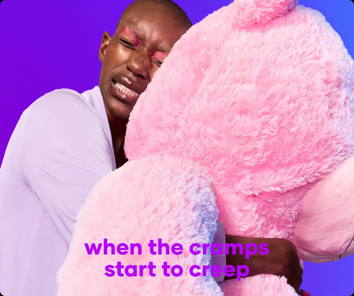 Person hugging a giant pink teddy bear on a cramp day