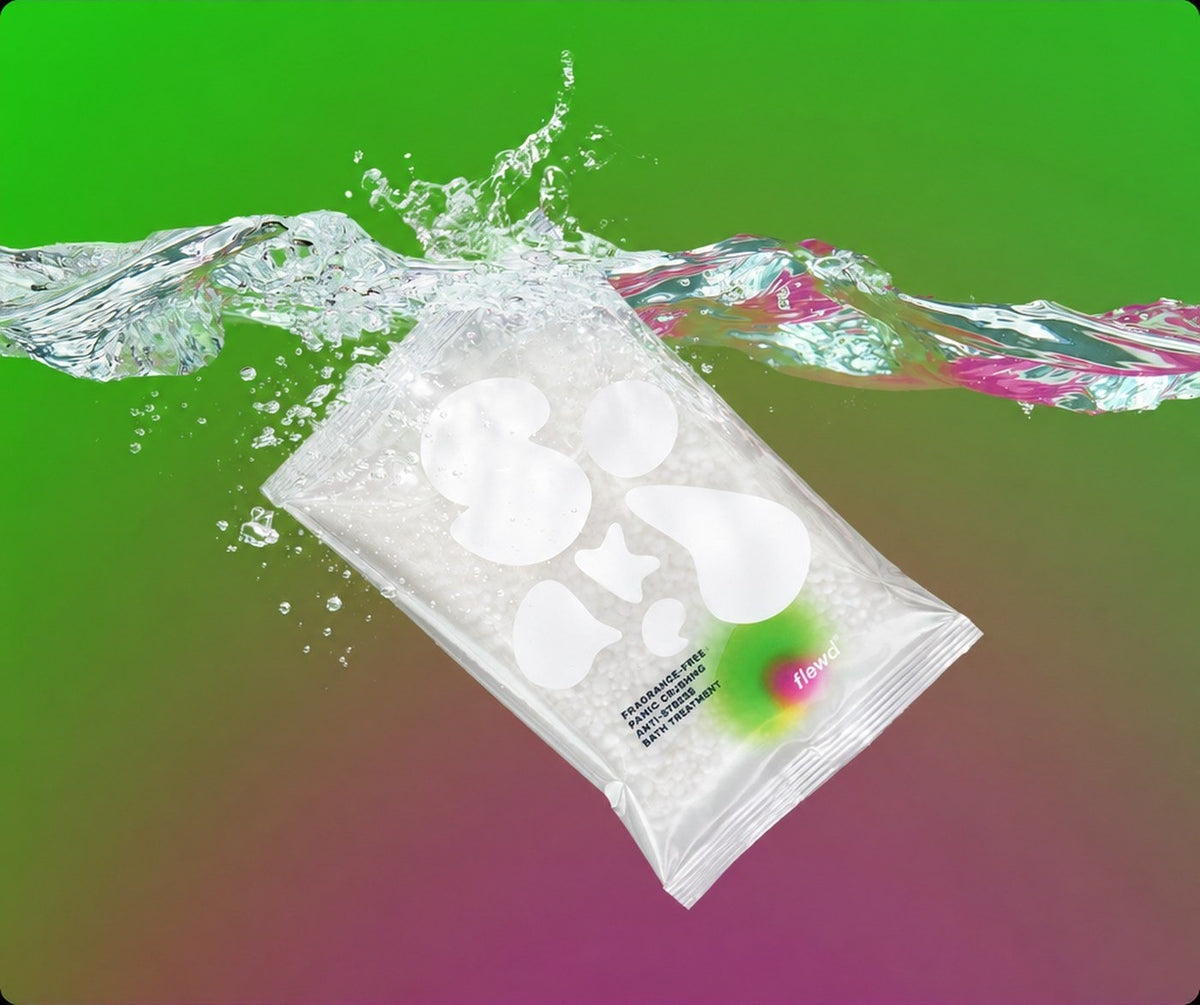 Flewd fragrance-free Panic Crushing magnesium bath soak clear pouch splashing into water on a green background