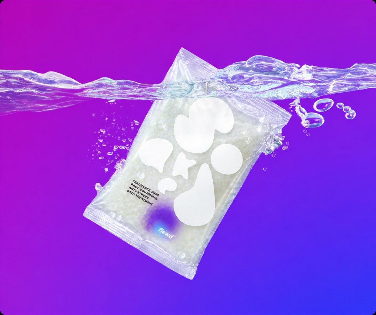 Flewd fragrance-free Rage Squashing magnesium bath soak clear pouch splashing into water on a purple background